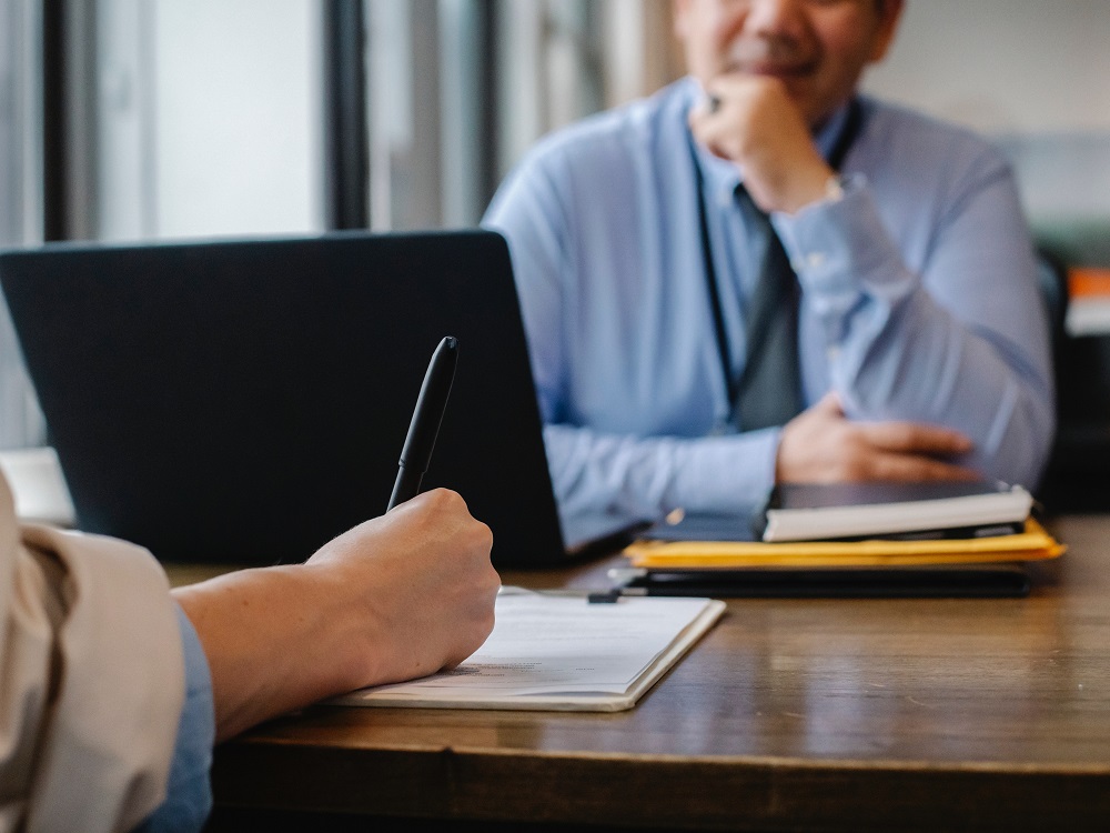 Photo of man signing document in office